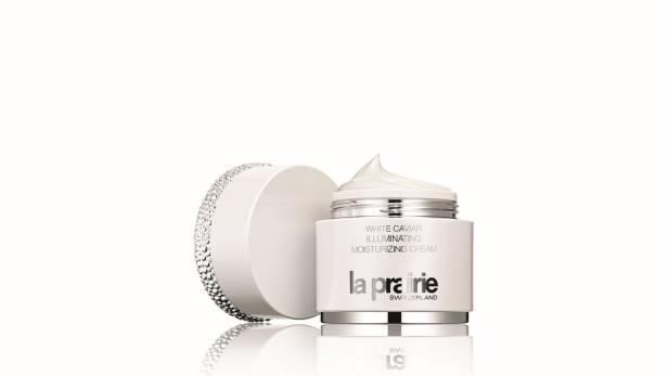 Ein geöffneter Tiegel „La Prairie White Caviar“-Feuchtigkeitscreme mit dem Deckel daneben.