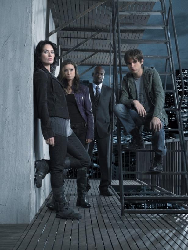 Die Besetzung der Fernsehserie „Terminator: The Sarah Connor Chronicles“ posiert auf einem Dach in der Nacht.