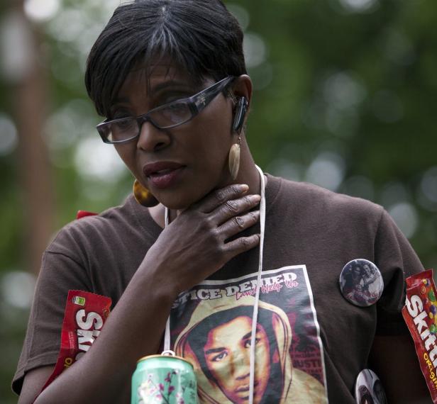 Eine Frau mit einem T-Shirt mit dem Aufdruck „Justice Denied“ und Bildern von Trayvon Martin.