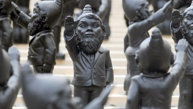 Eine Gruppe schwarzer Gartenzwerge mit erhobenem Arm.