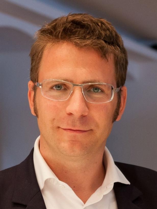 Florian Novak, geschäftsführender Gesellschafter Loung FM (c: lounge fm) Ein Mann mit Brille, weißem Hemd und dunklem Sakko blickt in die Kamera.