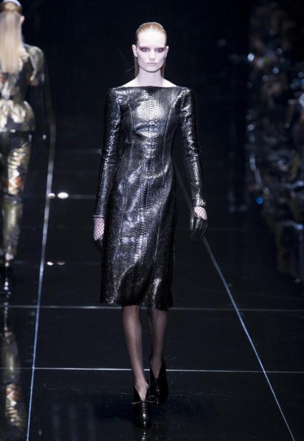 Eine Frau auf dem Laufsteg präsentiert ein silbernes Kleid in Schlangenlederoptik.