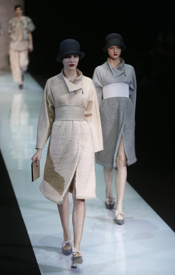 Zwei Models präsentieren gehobene Damenmode auf einem Laufsteg.