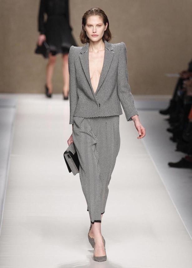 Eine Frau auf dem Laufsteg, gekleidet in einen Hosenanzug mit Zickzackmuster.