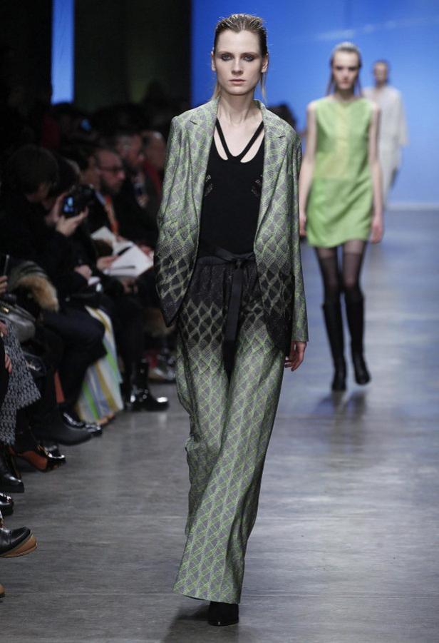 Eine Frau auf dem Laufsteg trägt einen Hosenanzug mit Rautenmuster.