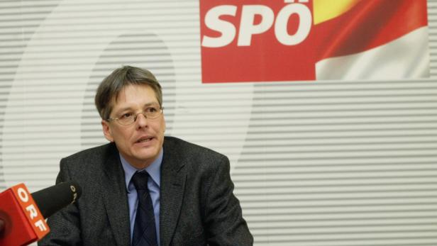 Ein Mann mit Brille spricht vor einem Mikrofon der ORF, im Hintergrund das SPÖ-Logo.