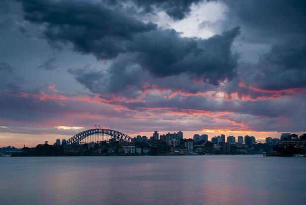 Die Skyline von Sydney mit der Harbour Bridge im Abendrot.