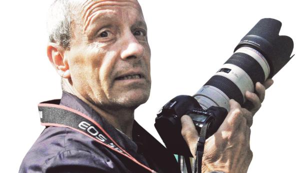 Ein Mann hält eine Canon EOS Kamera mit einem 70-200mm Objektiv.
