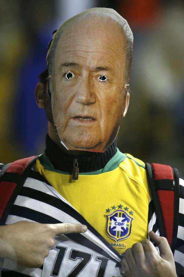 Ein Mann mit einer Maske von João Havelange und einem Trikot des brasilianischen Fußballteams.