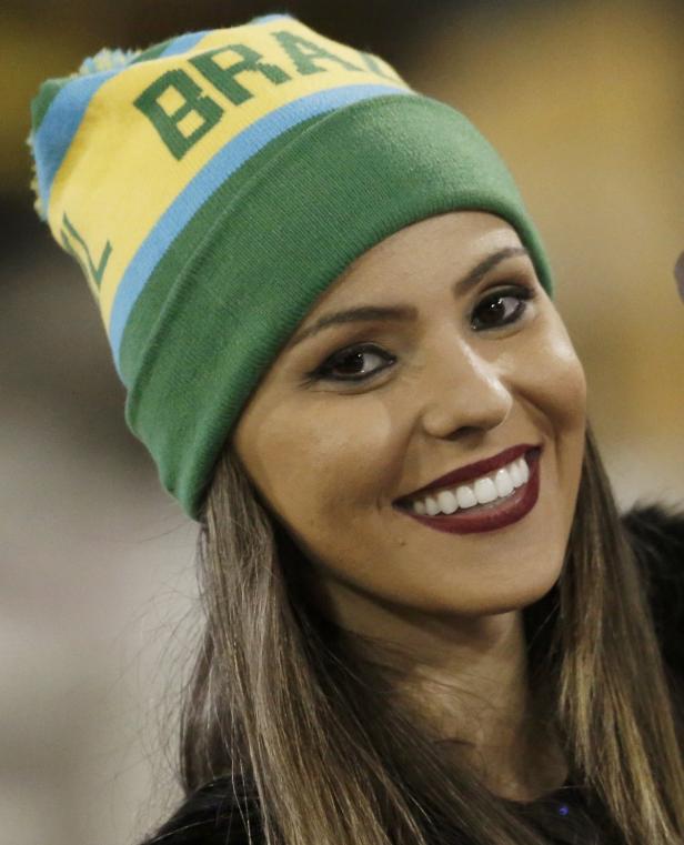 Eine lächelnde Frau mit einer Mütze in den Farben Brasiliens.