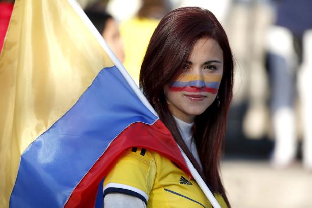 Eine Frau mit kolumbianischer Flagge und Farben im Gesicht.
