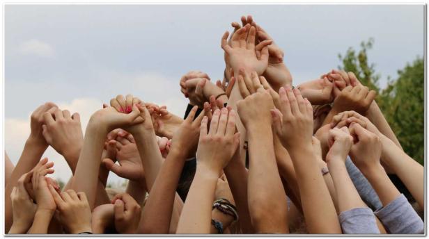 Viele Hände sind in die Luft gestreckt.