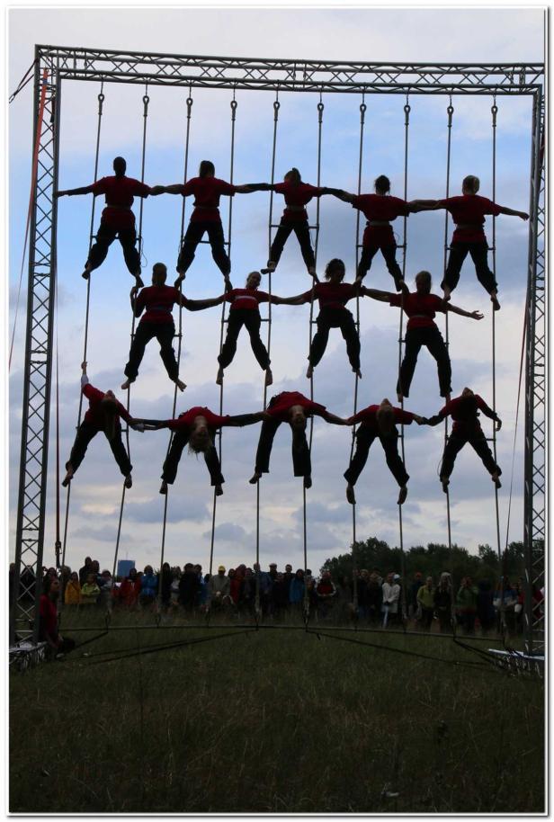 Eine Gruppe von Akrobaten performt an einem Gerüst vor Publikum.