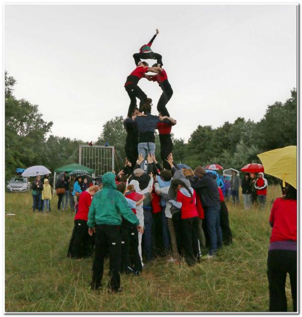 Eine Gruppe von Menschen bildet eine lebende Pyramide im Freien.