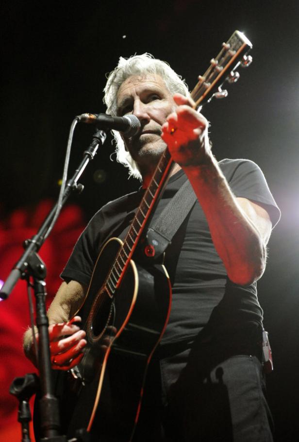 Roger Waters spielt Gitarre und singt während eines Konzerts.
