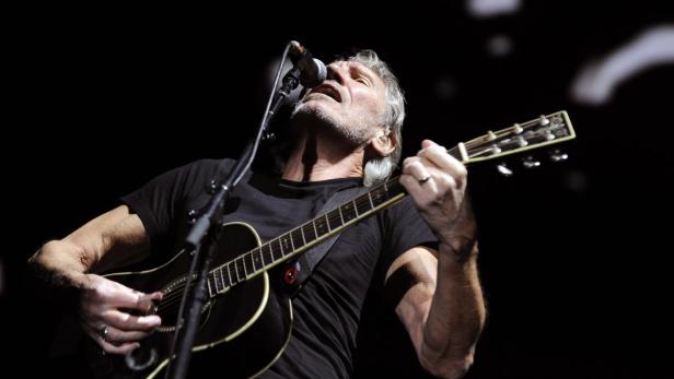 Roger Waters spielt Gitarre und singt während eines Konzerts.