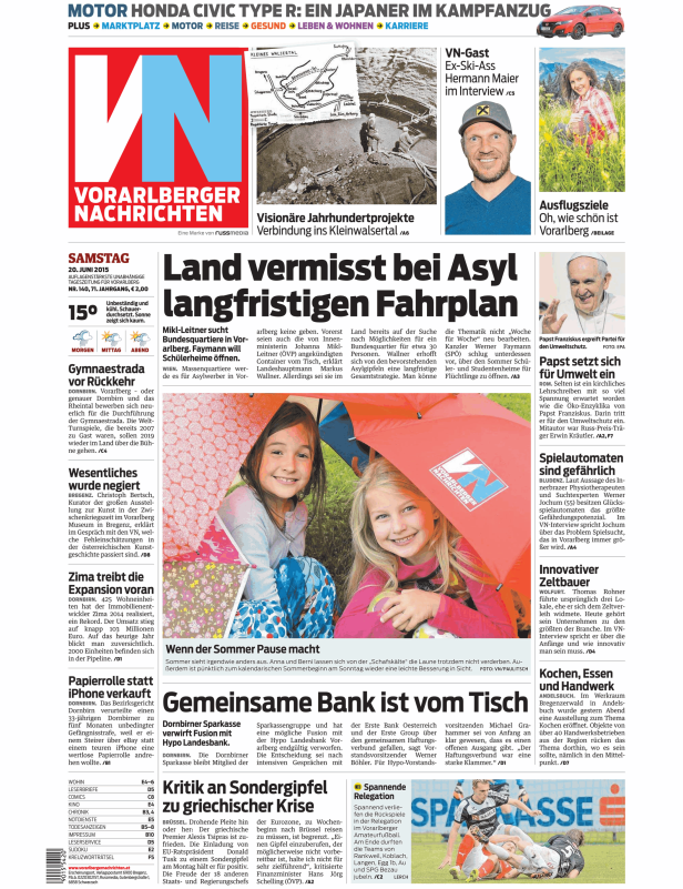 Zwei Mädchen sitzen unter einem Regenschirm der „Vorarlberger Nachrichten“.