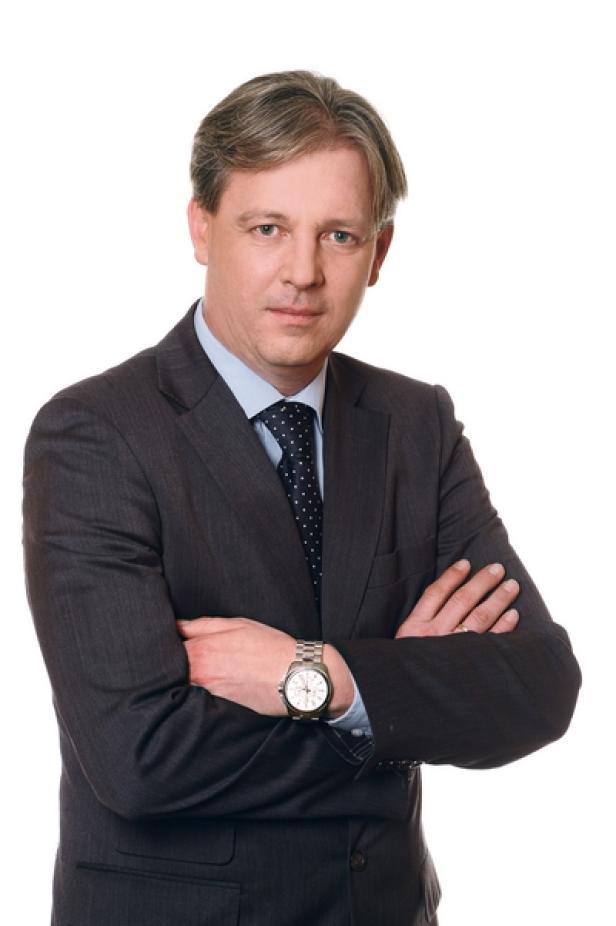 Roland Reischl, Geschäftsführer Redaktion und Produktion (c: regionalmedien austria) Ein Mann im Anzug mit verschränkten Armen vor einem weißen Hintergrund.