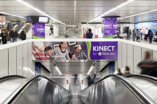 Eine Rolltreppe führt in eine U-Bahn-Station mit Werbung für Kinect für Xbox 360.