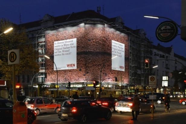 Ein Gebäude in Wien ist mit einem riesigen Werbeplakat für Sachertorte verhüllt.