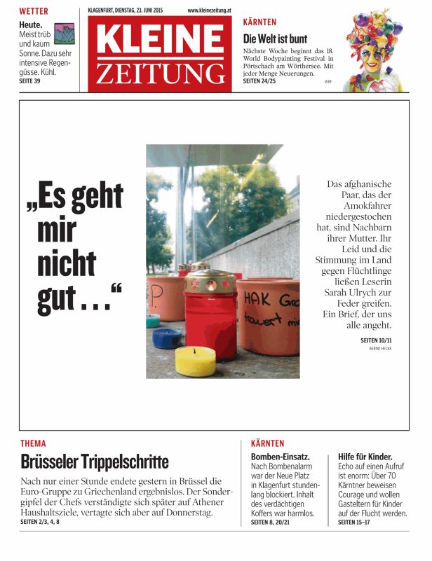 Mehrere brennende Kerzen stehen vor einem Gebäude.