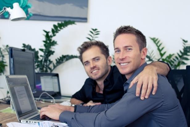Mark und Martin Poreda, kununu.com-Gründer (c: kununu) Zwei Männer sitzen zusammen an einem Schreibtisch mit Laptops.