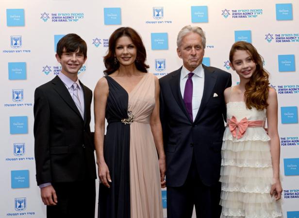 Michael Douglas, Catherine Zeta-Jones und ihre Kinder posieren vor einer Wand mit dem Logo des Genesis-Preises.