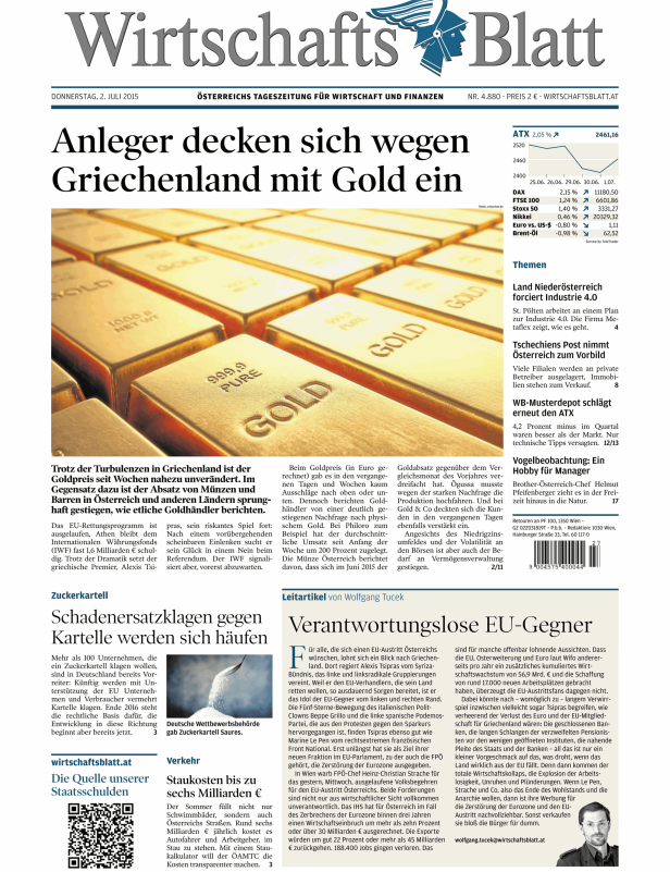 Eine Nahaufnahme von Goldbarren vor dem Hintergrund der Titelseite des Wirtschaftsblatts.