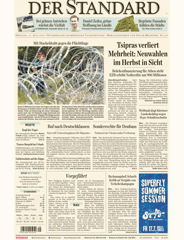 Polizisten stehen hinter einem Stacheldrahtzaun, der Flüchtlinge abhalten soll.