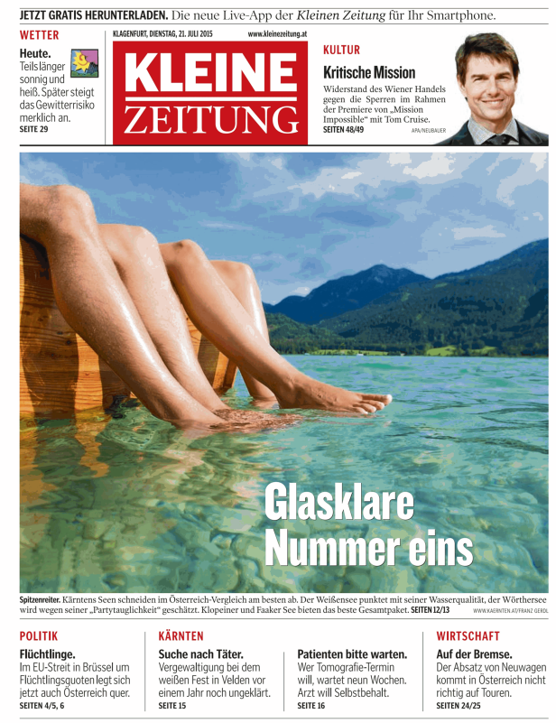 Zwei Personen sitzen mit den Füßen im klaren Wasser eines Sees.