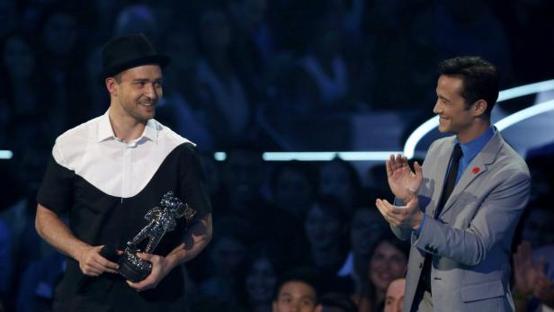 Justin Timberlake hält eine Auszeichnung, während Joseph Gordon-Levitt applaudiert.
