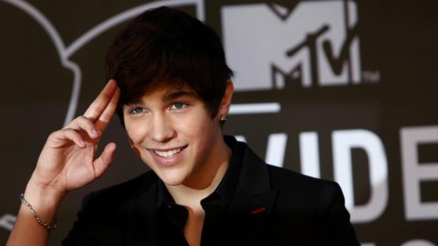 Austin Mahone posiert auf einem Event vor einem MTV-Logo.