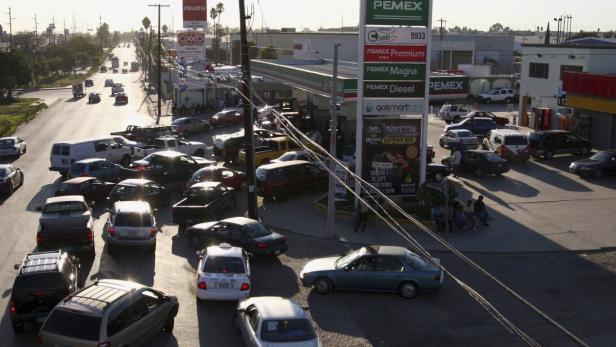 Eine überfüllte PEMEX-Tankstelle mit einer langen Schlange von Autos.