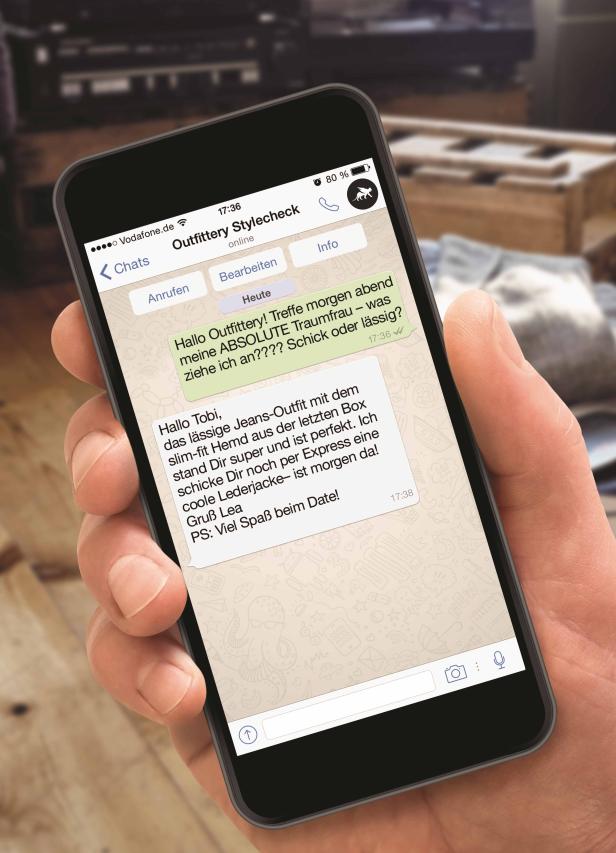 OUTFITTERY STYLECHECK (2).jpg Eine Hand hält ein Smartphone mit einem Chat von Outfittery Stylecheck.
