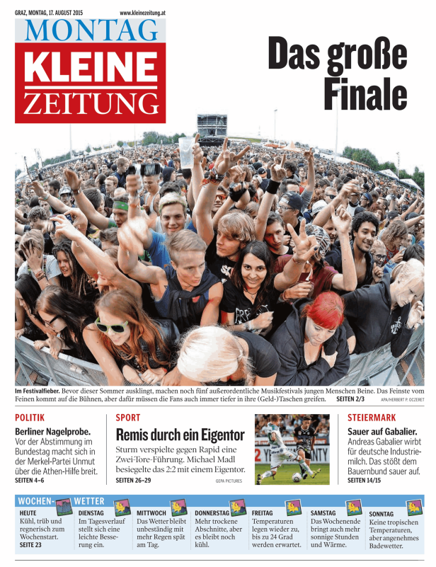 Eine große Menschenmenge jubelt auf einem Musikfestival vor einer Bühne.