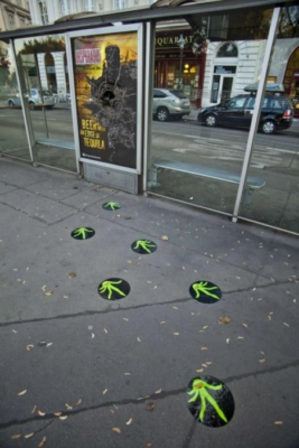 Desperados Bier - Heineken - Super-Fi Grüne Fußabdrücke führen zu einer Bushaltestelle mit einem beschädigten Werbeplakat.