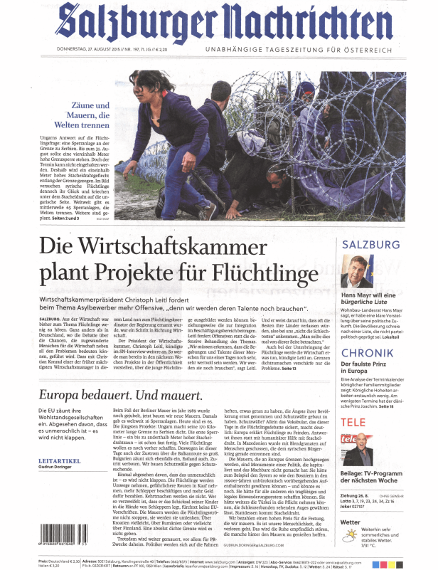 Flüchtlinge kriechen unter einem Stacheldrahtzaun an der ungarisch-serbischen Grenze.