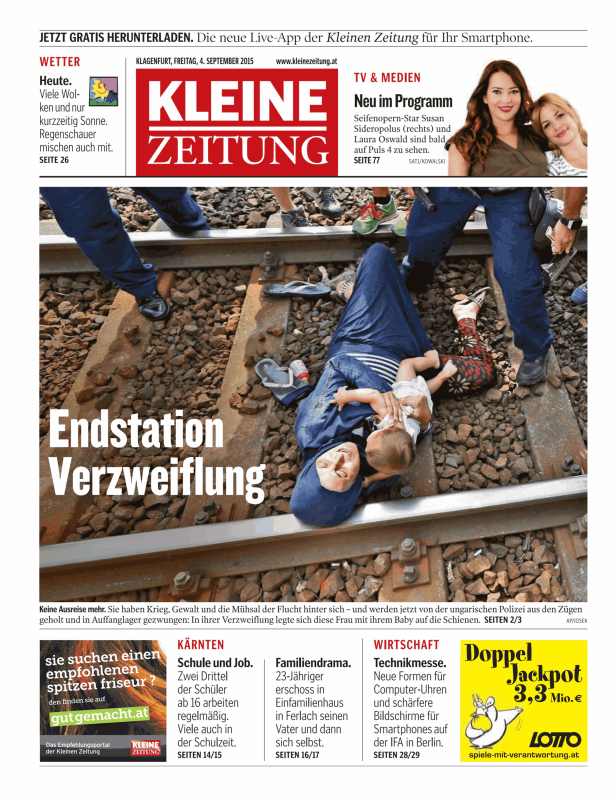 Eine Frau liegt mit ihrem Baby auf Bahngleisen.