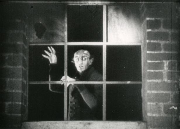 Graf Orlok, eine Figur aus dem Film „Nosferatu“, steht am Fenster.