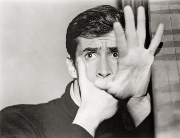 Anthony Perkins in einer Szene des Films „Psycho“ mit erhobenen Händen vor dem Gesicht.