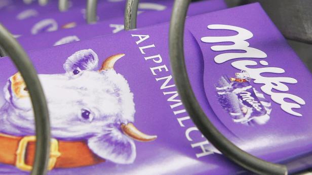 Nahaufnahme von Milka Alpenmilch Schokoladentafeln in einem Verkaufsautomaten.