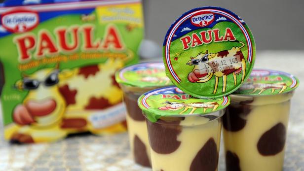 Mehrere Becher Dr. Oetker „Paula“ Pudding mit Kuh-Motiv sind zu sehen.