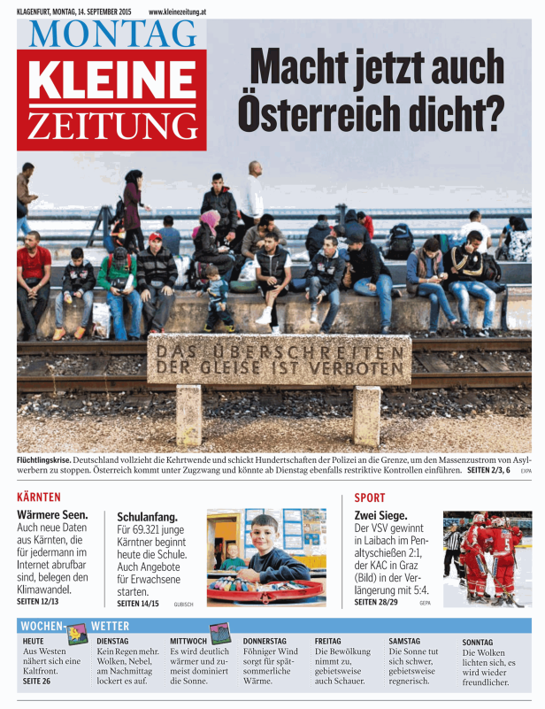 Eine Gruppe von Menschen sitzt an einem Bahnsteig mit der Aufschrift „Das Überschreiten der Gleise ist verboten“.