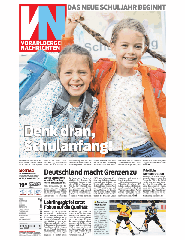 Zwei lachende Mädchen mit Schultüten und Rucksäcken freuen sich auf den Schulanfang.