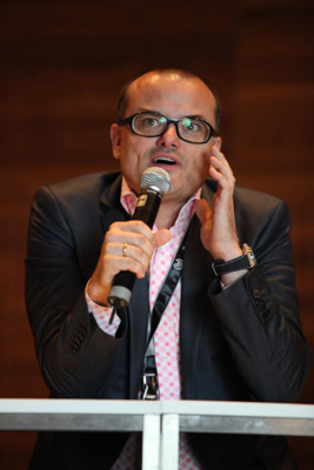 Ein Mann mit Brille spricht in ein Mikrofon.