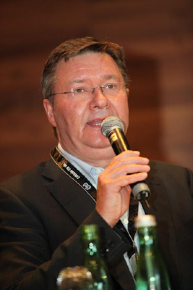 Ein Mann mit Brille spricht in ein Mikrofon.