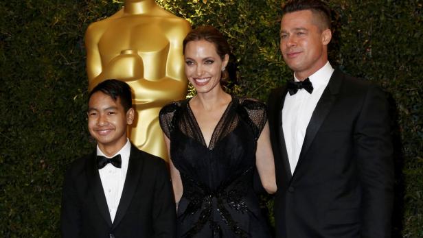 Angelina Jolie, Brad Pitt und Maddox Jolie-Pitt posieren auf dem roten Teppich.