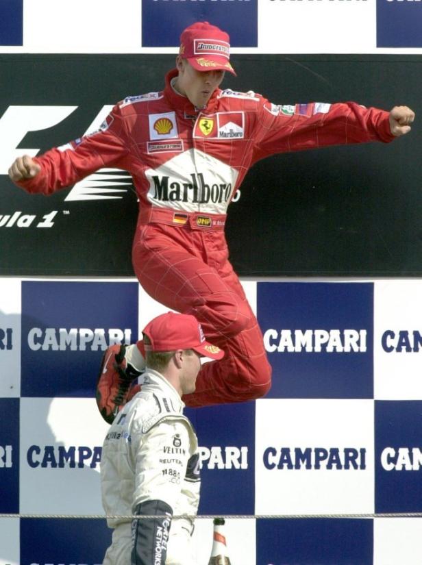 Michael Schumacher springt auf dem Siegerpodest vor Freude in die Luft.