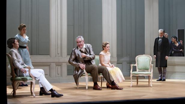 Szene aus einem Theaterstück mit mehreren Darstellern in Kostümen auf der Bühne.