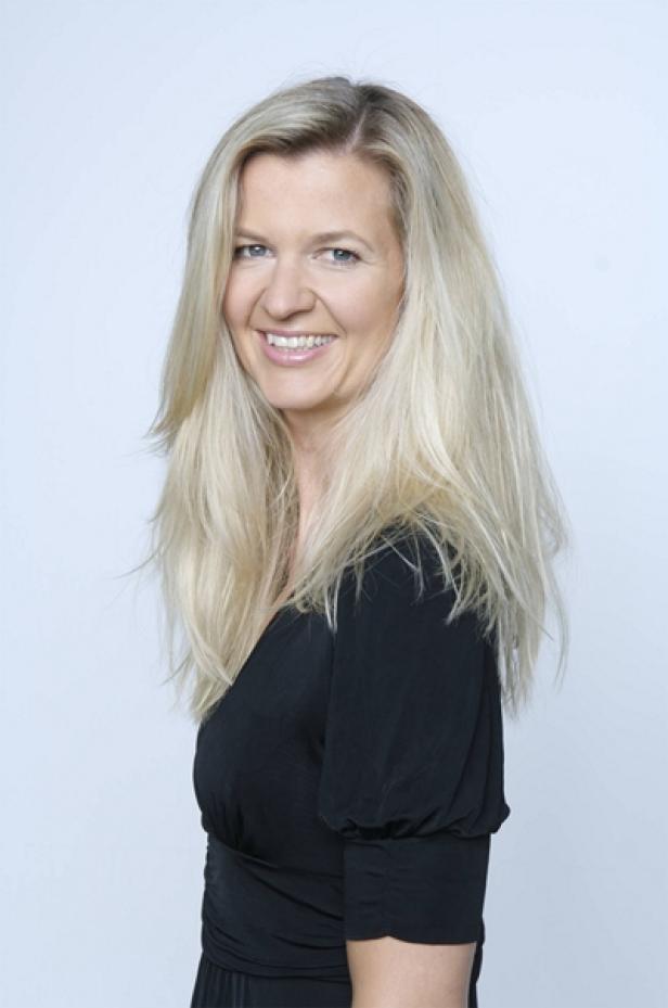 Lowe GGK-Kampagne für das Haus der Barmherzigkeit Wien (c: picturedesk) Eine lächelnde Frau mit langen blonden Haaren und einem schwarzen Kleid.